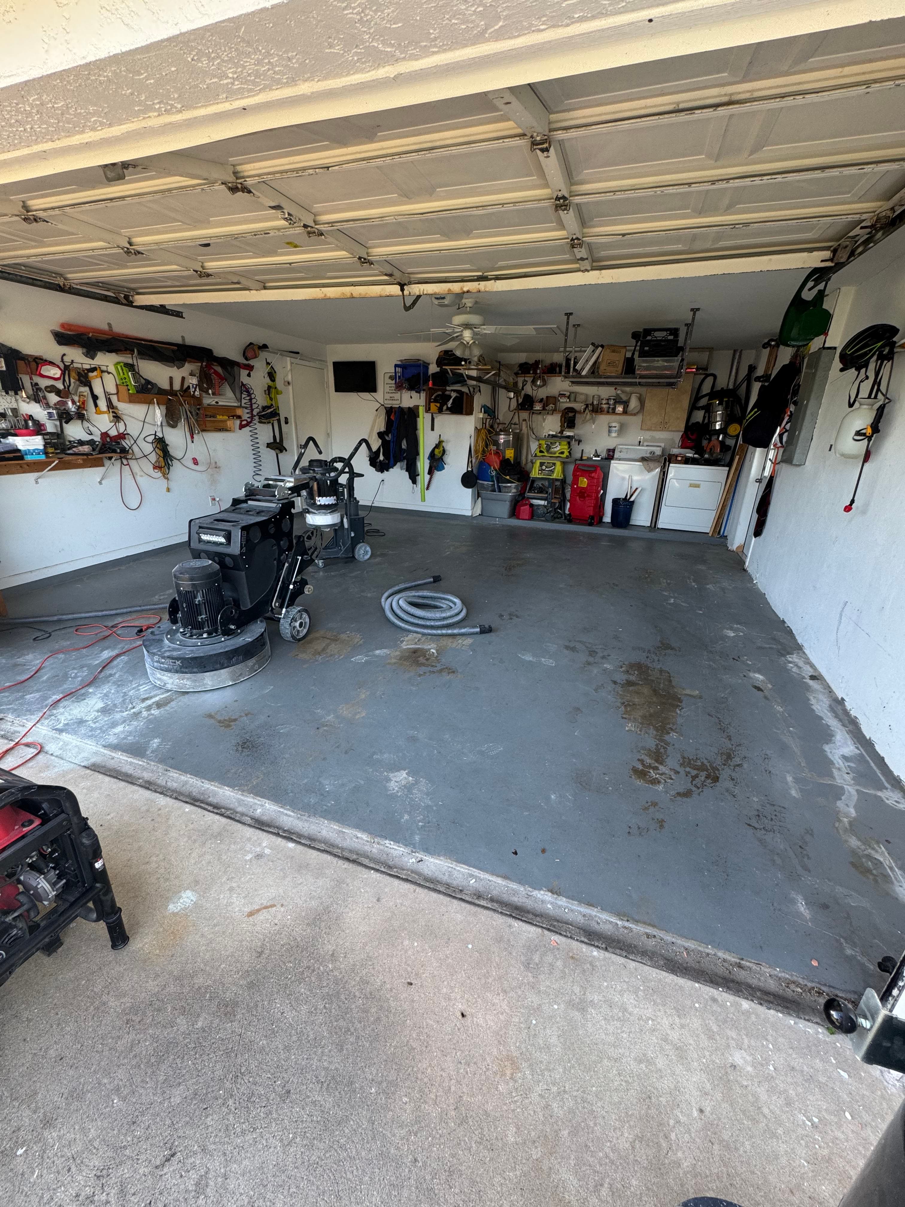 Garage floor being ground with industrial grinder